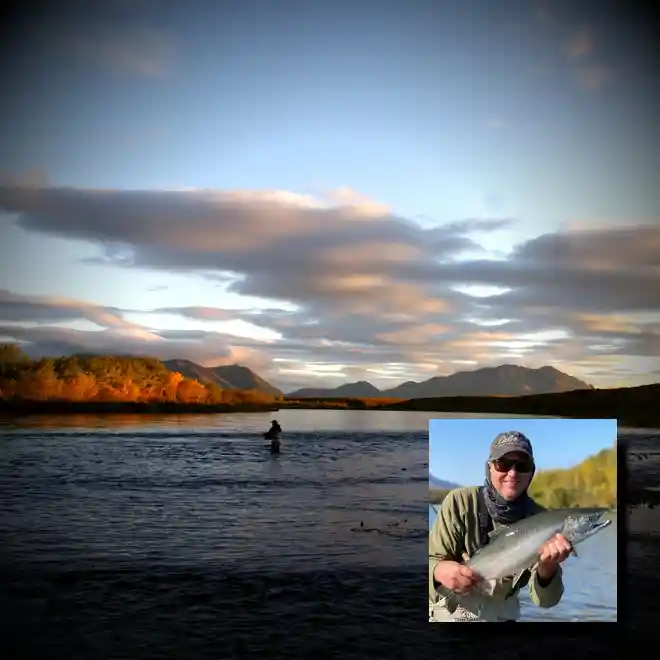 Togiak River scenic view of angler fishing and guide holding bright silver salmon in Alaska wilderness